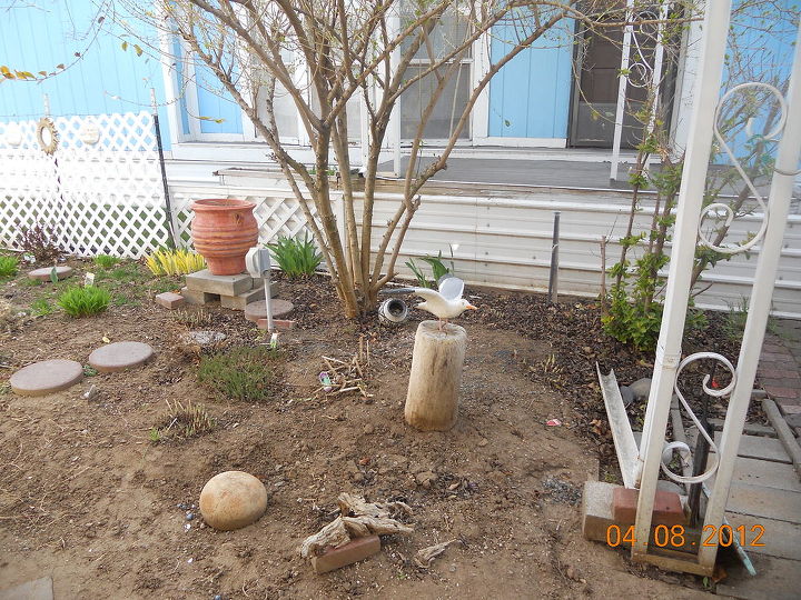 q help with my little garden, flowers, gardening, looks pretty dismal here now but this is where the hostas live under the shade this is my primary view my deck is straight across from this this bush hides the neighbors unkempt trailer when it is in leaf About 8 ft wide to the path in front of my deck porch