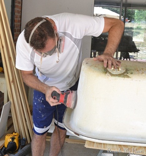 how we refinished our antique claw foot tub, bathroom ideas, diy, how to, repurposing upcycling, My husband sanding the sides