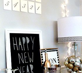 from holiday to new year s eve lamp using a fillable glass lamp, lighting, seasonal holiday decor, We added a countdown some chalkboard art framed gold foil art twinkle lights and some gilded bubbly to create a beautiful festive scene that your guests will love