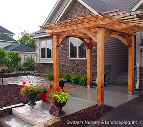 custom cedar arbor enhances home s front entrance and paver patio provides sitting, Flower pots allow for seasonal color changes