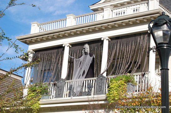 scary outdoor halloween decorations, halloween decorations, porches, seasonal holiday decor, Black draping and a ghost blow in the wind
