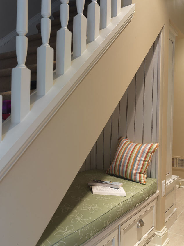 Oftentimes the space under the stairs is used for storage. The creative designers at Case Design/Remodeling, Inc. turned it into a cozy and cushioned "reading nook" where the homeowners could sneak away and relax. The space is also welcoming for the kids with a storage bench under the stairs for the kids to sit and put their shoes on. The kids also enjoy just hanging out in the nook and reading.