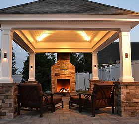can a lovely backyard retreat be budget friendly, curb appeal, fireplaces mantels, landscape, outdoor furniture, outdoor living, At the edge of a patio beside a lovely shingle roof gazebo pergola this fireplace not only offers warmth in autumn and winter months but it creates the perfect ambience for conversation