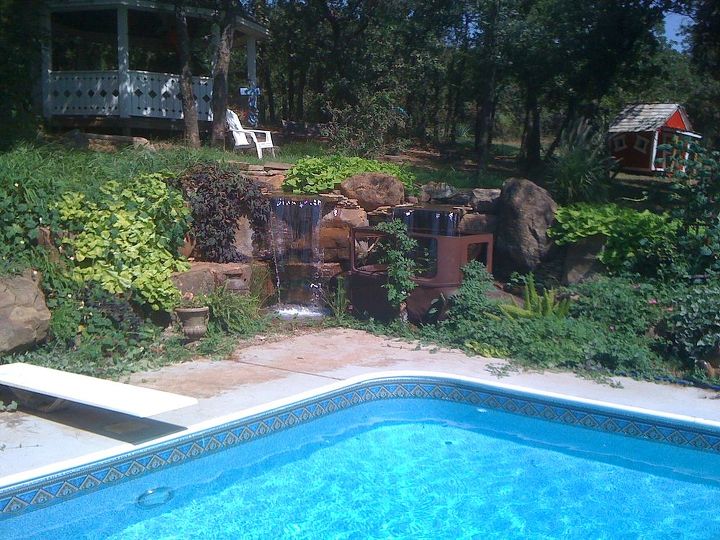 antique car pondless waterfall, landscape, outdoor living, ponds water features, repurposing upcycling, This pondless waterfall is a great backdrop for the swimming pool
