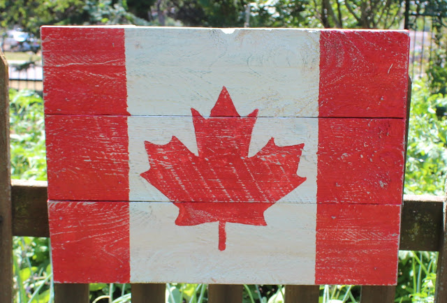 pallet wood flag, pallet, patriotic decor ideas, repurposing upcycling, seasonal holiday decor, woodworking projects, Started by dividing the boards into 1 4s and painting red over the outer two 1 4 leaving a white middle A simple maple leaf image enlarged and traced onto the white painted wood