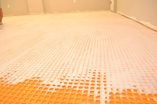 installing schluter ditra tile underlayment, flooring, tile flooring, tiling, The dovetail cut back cavities are filled with additional mortar and tile is laid overtop