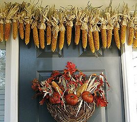 my front porch for fall pumpkins fall flowers lanterns and a fun corn garland, curb appeal, flowers, home decor, seasonal holiday decor, My corn garland and thrifting find basket filled with leaves pyracantha berries dried corn and pumpkins