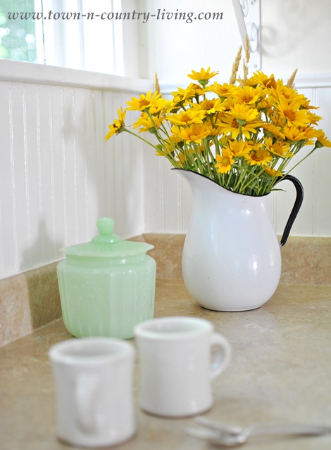 add summer style to a country kitchen, home decor, kitchen design, Sunny yellow flowers are haphazardly placed in a white enamel pitcher