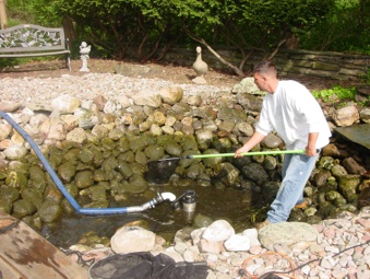 ecosystem pond maintenace spring pond or water garden maintenance tip, home maintenance repairs, outdoor living, ponds water features, First drain the pond down to a few inches and pump some of the water into a storage tank for the fish Now we can catch the fish more easily place them in the tank and cover them up This is a good time to check your pond lighting