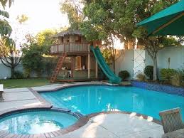 backyard retreats, WOW A playhouse that has a slide down into the pool I am there