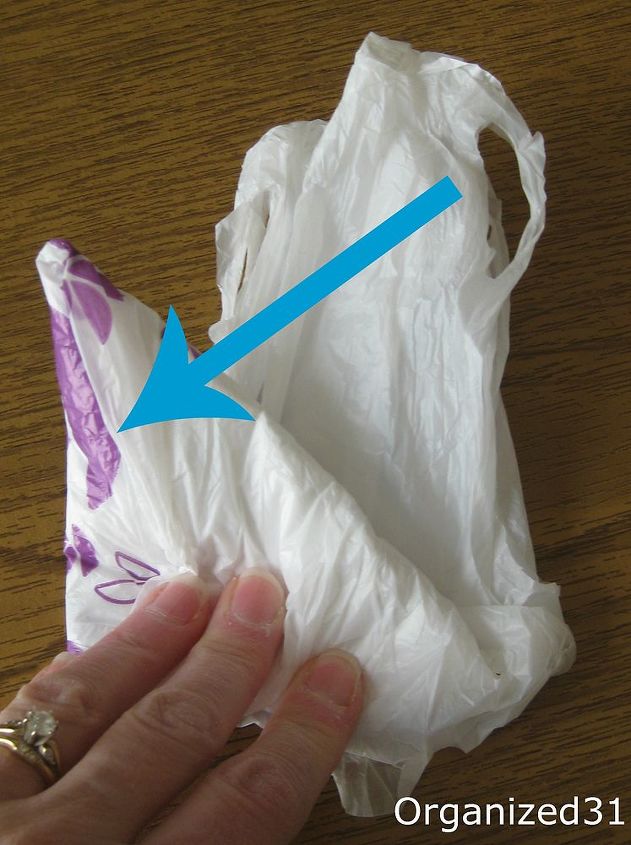 how to fold plastic shopping bags to take up less space, cleaning tips, Tuck the ends of the handles into the open edge of the last triangle you folded