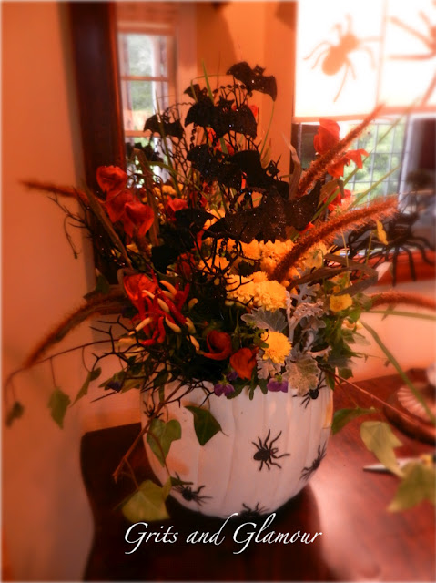 plantador de abbora falso, Aqui est outro vaso decorado com adesivos de aranha e plantado com flores mortas teias de aranha e caules pretos brilhantes com morcegos