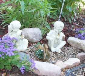 purple and yellow winners in the garden, flowers, gardening, raised garden beds, Purple annual ageratum Hybrid in my new little garden feature this year boy and girl garden statues holding jar with firefly solar powered looks so pretty at night