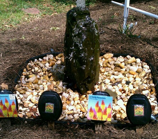 new flower signs from recycled mini picket fencing, container gardening, flowers, gardening, This is our anniversary rock fountain and I planted these new flowers in front of it These are my new flower markers