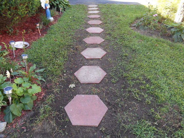 finally cool enough to set the octagon paver walk way in the ground, concrete masonry, diy renovations projects, gardening, The lay of the land made it neccessary lift a few and dig them out with a hand tool No extra soil needed