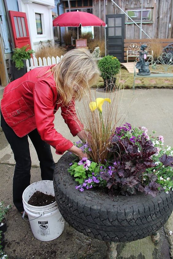 up cycled tire planter, container gardening, flowers, gardening, perennials, repurposing upcycling, Step 6 Fill in with soil between the newly transplanted pots and water in generously