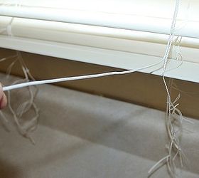 how to shorten faux wood blinds, home maintenance repairs, how to, window treatments, windows, Here s the excess string the one horizontally held out is the main pulley string and the bunchy ones at the bottom right are the ladder strings which hold the slats into place