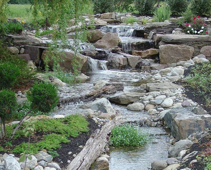 water features waterfalls, outdoor living, ponds water features, Logs and stumps help to naturalize this waterfall and stream Learn more about our waterfall construction click on this link