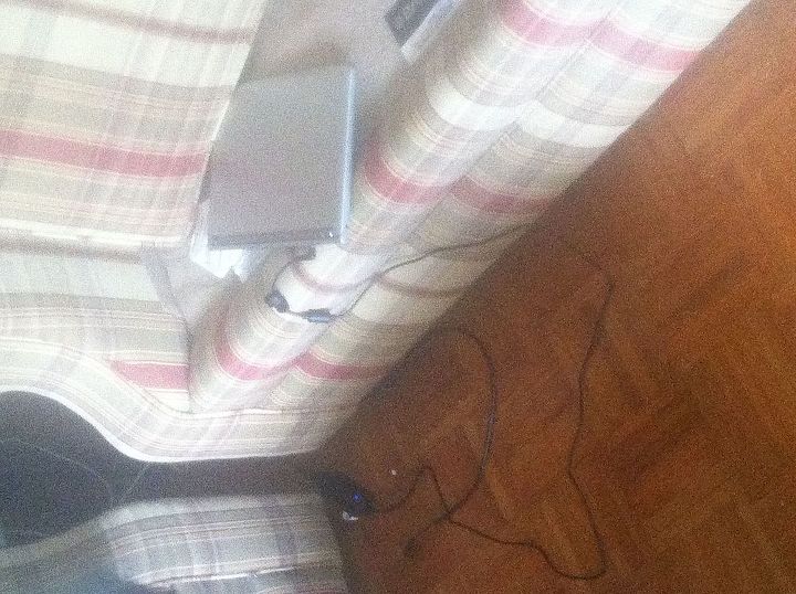 problemas de segurana eltrica em casa, Um laptop sendo carregado em um sof de tecido parcialmente coberto