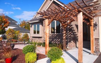 Custom cedar arbor enhances home's front entrance and paver patio provides sitting and gathering area.
