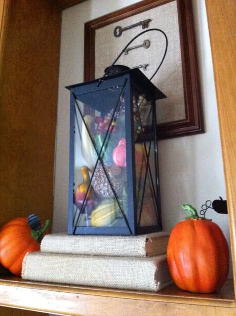 fall mantle, crafts, seasonal holiday decor, I filled a lantern with somesmall faux pumpkins gourds and acornsand set it up on some thrifted books I covered in burlap See more at