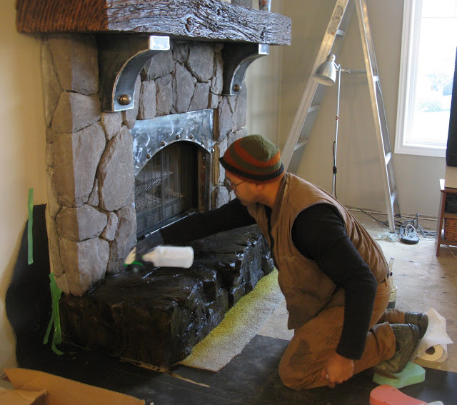 revamping an outdated brick fireplace without destruction, concrete masonry, fireplaces mantels, home decor, Phoenix from hand carved the base out of a solid piece of fibreglass reinforced concrete and is shown here staining it to resemble the cultured stone
