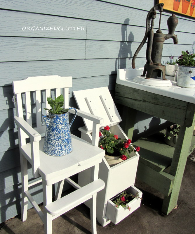 uma cozinha ao ar livre caprichosa, Mais esquerda uma cadeira alta vintage e meu balde de batata cebola reaproveitado para guardar flores