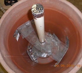 umbrella holder in a cement plant container, old gutter wires to hold the pvc pipe in place for cement to pour