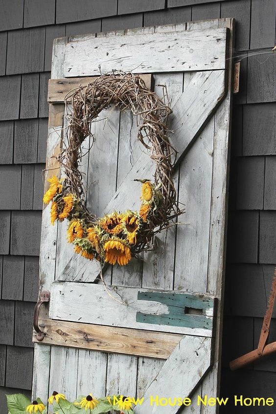 using faded flowers in my fall decor, seasonal holiday d cor, wreaths, The old barn door sits against the back of the garage in our vegetable patch The sunflowers provide a touch of colour to this rustic palette
