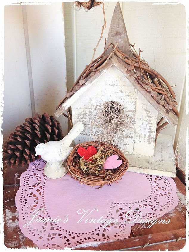 valentine s day porch, home decor, porches, seasonal holiday decor, valentines day ideas, I placed a pink doily onto the top of this vintage crate and made this love nest out of a bird nest by filling it with moss and hearts