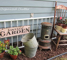 new finds and a new outdoor vignette, flowers, gardening, outdoor living, repurposing upcycling, The new old pails join a newly created vignette with terra cotta pots and the bean pots that were too shaded on the covered patio and not blooming well An old futon metal back is repurposed as a fence