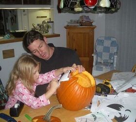 more pumpkins for my girls, crafts, seasonal holiday decor, Hannah punching the holes of the pattern