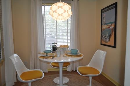 um novo comeo para um recanto de pequeno almoo, A mesa Tulip de 30 estilo Eero Saarinen e quatro cadeiras com almofadas amarelas brilhantes da InStyleModern com s o a pe a central do recanto