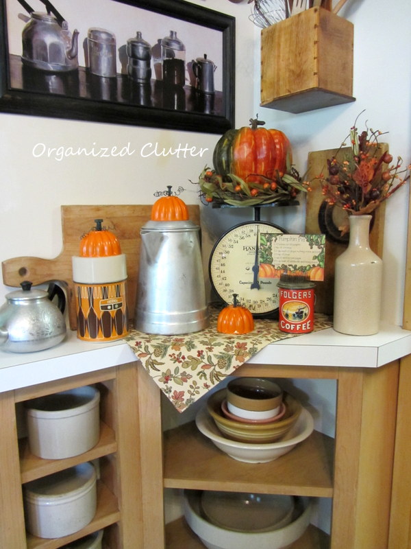 a fall kitchen vignette with jello mold re purposed pumpkins, repurposing upcycling, seasonal holiday d cor, Breadboards a scale coffee pot and teapot Folger s coffee puzzle pumpkin pie recipe flower frog an orange thermos and faux fall foliage