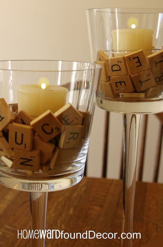 juega con la decoracin de tu mesa de accin de gracias, Las letras del Scrabble rodean una candelita en un recipiente transparente en un portavotivas con pie transparente