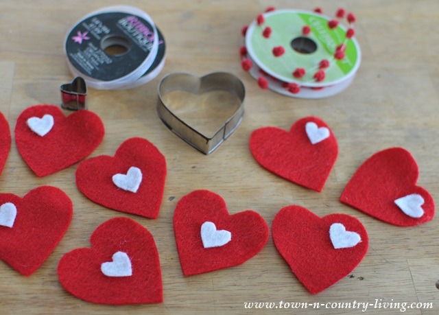 easy diy felt heart valentine s banner, crafts, seasonal holiday decor, valentines day ideas, Trace and cut out felt hearths and then hot glue tiny white hearts onto larger red hearts