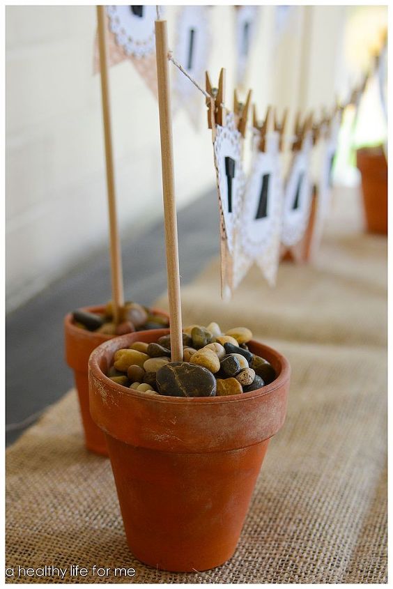 thanksgiving diy banner, crafts, seasonal holiday decor, thanksgiving decorations, Use sand and smooth river rock to stabalize the small terra cotta pots that hold your banner
