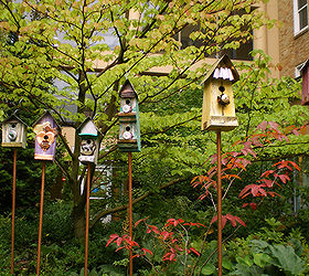 placing birdhouses in the garden, flowers, gardening, Multiple birdhouses can add a splash of color and depth to your garden You must make sure the birds that would reside in this type of house will get along though No one wants a feathered quarrel
