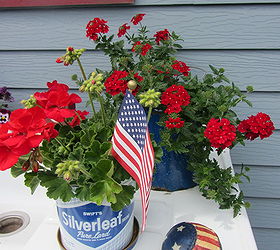 my potting bench has gone red white blue, flowers, gardening, outdoor living, A hand painted stars and stripes baseball sits to the right of the red geranium A verbena is in the background