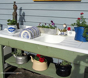 a whimsical outdoor kitchen, flowers, gardening, outdoor living, Vintage tea kettles are planted with annuals on the bottom shelf and on the right side drainer