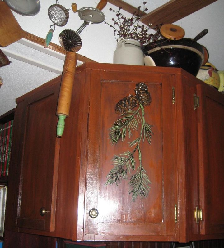 rustic kitchen cabinets get a country design with plaster stencils, home decor, kitchen cabinets, kitchen design, A darker brown color wash was rubbed over the pine branches then wiped off to settle in to the recesses This brings out further detail