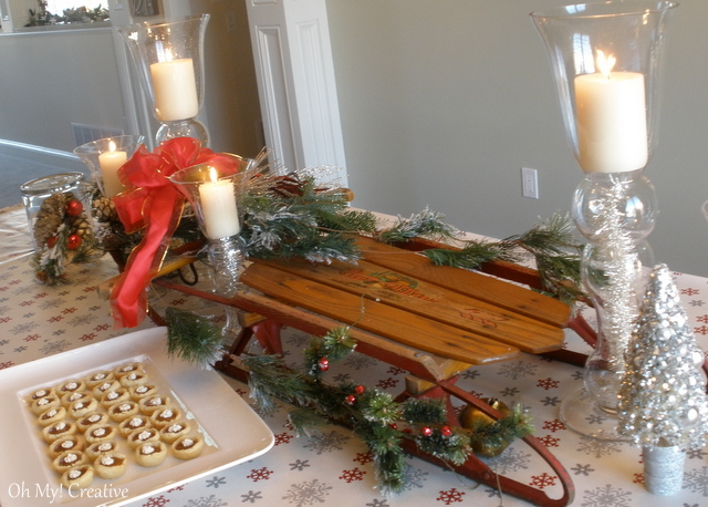 vintage sled tablescape centerpiece, home decor, seasonal holiday decor, woodworking projects, Flexible Flyer Sled greens gilded pine cones and a bow make this a pretty holiday centerpiece