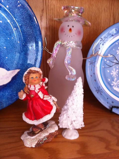 christmas china hutch decor, christmas decorations, seasonal holiday decor, A little girl skating by a miniature tree sits in front of an icy glass snowman