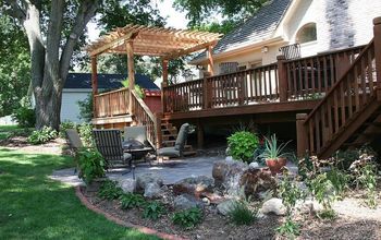 Creating a backyard retreat with a new patio, water feature, and an expanded deck with pergola in Nebraska City, NE