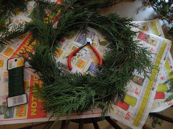 christmas wreath candle ring, christmas decorations, crafts, seasonal holiday decor, wreaths, Using an old wire form and floral wire I began attaching small pieces to the form till the wreath was full enough
