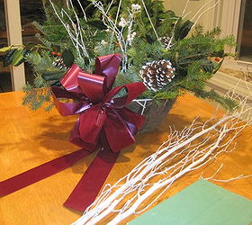 holiday hanging basket for under 10, crafts, seasonal holiday decor, Just put a wet floral block in the basket bottom and push your cut greens into it from outside edge toward inside Add some painted white sprigs some pinecones Holly and a bow