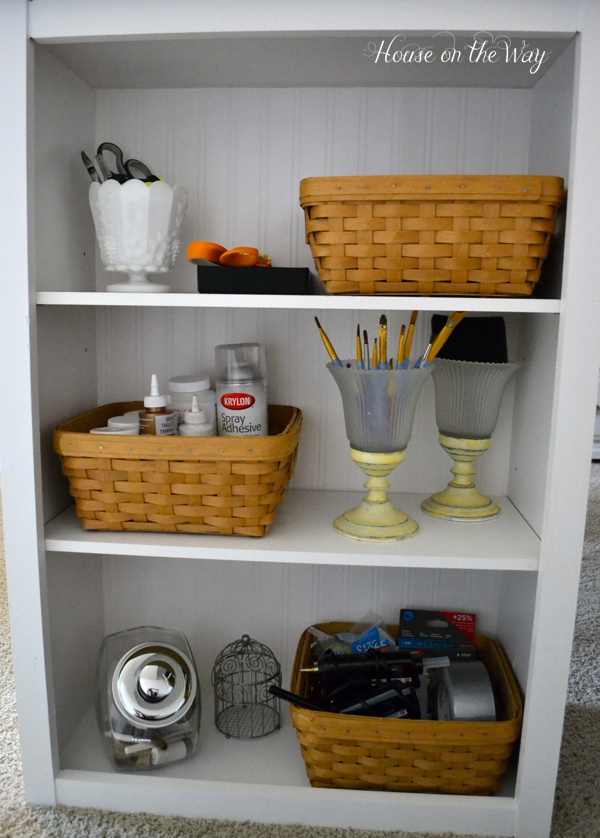 how to make a craft table, One side of the bookcase holds a variety of supplies