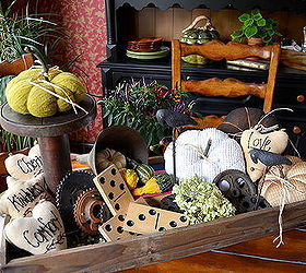 fall bounty in a vintage bulb tray, seasonal holiday d cor, Vintage fabric pumpkins old automotive gear plates a tin funnel and a tall wooden spindle are just some of the items used in this kitchen table display