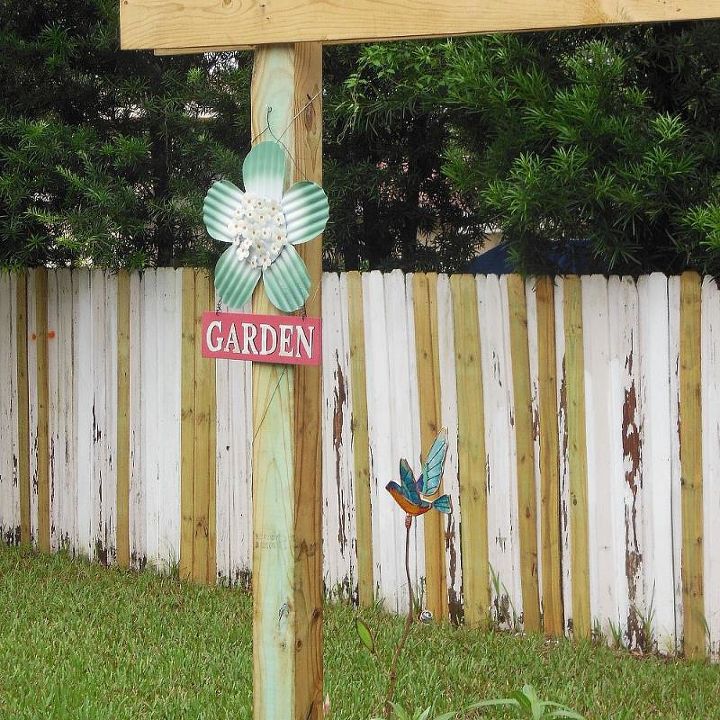 a labor of love, flowers, gardening, hibiscus, The fence repairs are almost done Added some garden art that I found on sale 9 18 13
