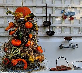 my favorite garden repurpose potting sink fountain, gardening, outdoor living, seasonal holiday decor, thanksgiving decorations, Fall a gourd tower made from hay gourds and a bottle drying rack with a burlap skirt